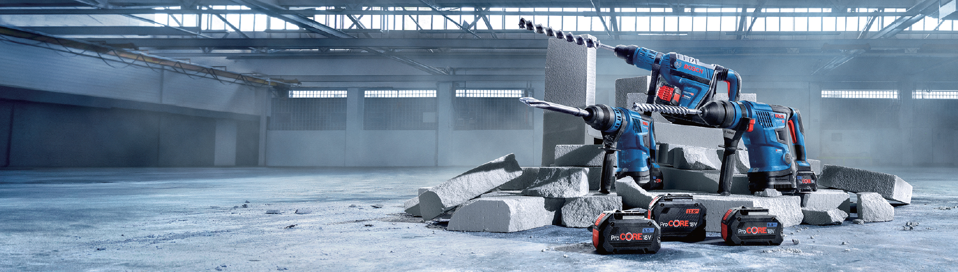 Two blue Bosch Professional tools are next to gray concrete parts.