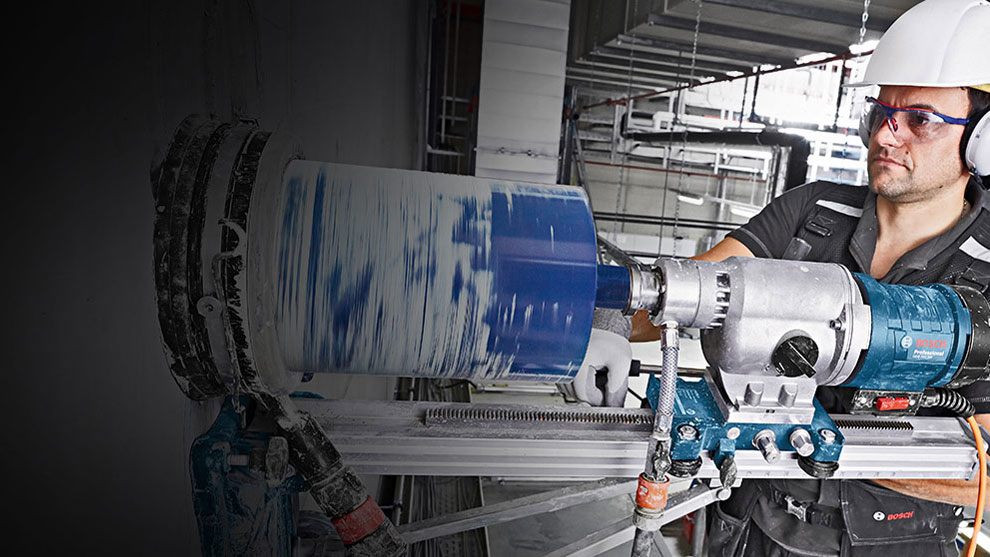 A craftsman is using a Bosch Professional drill on a wall.