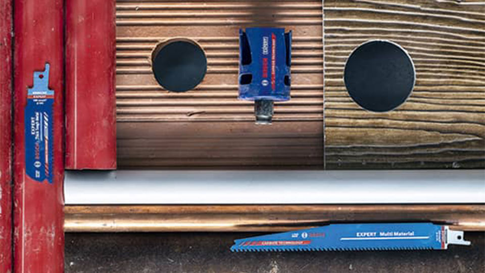 Bosch Professional saw blades are lying on wooden boards and pipes.