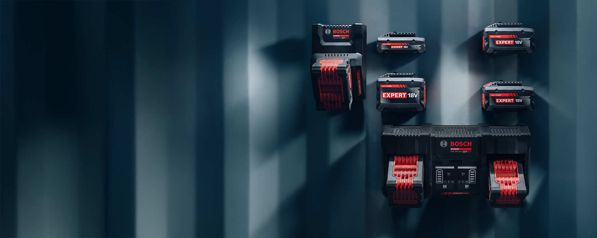 Several Bosch Expert 18V batteries and chargers on a wall.